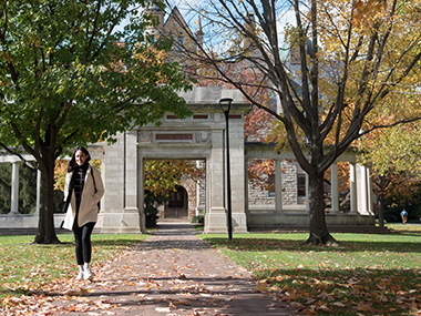 Student walking across Tappan Square on a bright autumn day.