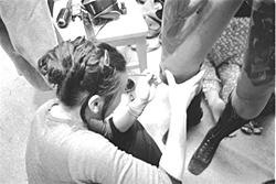 Photo of student painting on another student