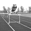Photo of Amie Ely jumping hurdles