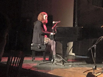 Photo of student performing with a piano at an open mic night